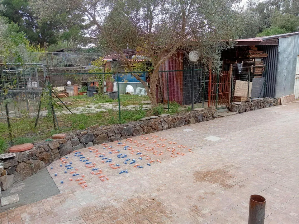 Area esterna con muretto in pietra e pavimentazione nuova, giardino sullo sfondo